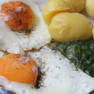 Spinach with Fried Eggs and Boiled Potatoes on a Plate