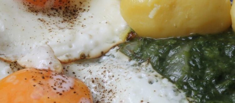 Spinach with Fried Eggs and Boiled Potatoes on a Plate