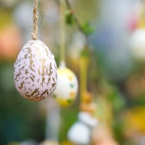 Decorated Easter eggs hanging from an Easter tree branch, symbolizing German Easter traditions.