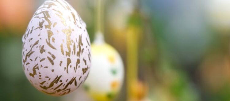 Decorated Easter eggs hanging from an Easter tree branch, symbolizing German Easter traditions.