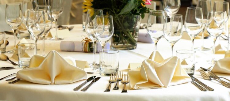 A beautifully arranged German dining table with white tablecloth, elegant glassware, and neatly placed cutlery.