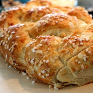 Close-up of a freshly baked Hefezopf topped with sugar crystals and almond slices.