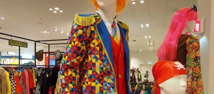 Colorful carnival costumes in Germany, including a clown with a tailcoat and top hat, a pirate costume for children, and other vibrant disguises.